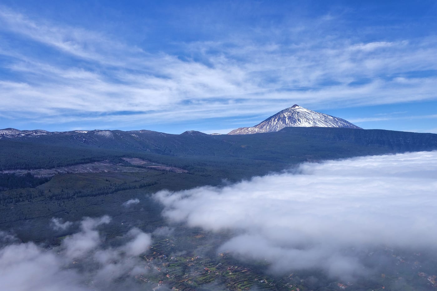 Parapente volando sobre un mar de nubes con el Teide al fondo, Tenerife.
