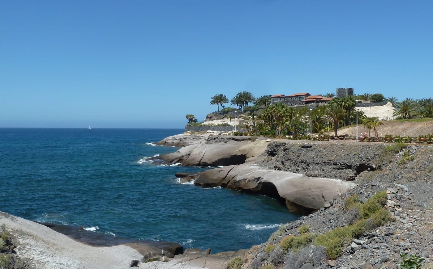 Vista de la Playa de Fañabé en Costa Adeje, Tenerife, con su arena dorada y los hoteles del paseo al fondo.