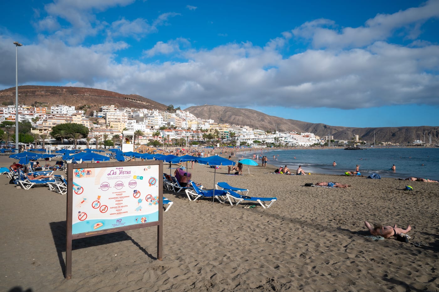 Vista de la amplia franja de arena dorada de la Playa de las Vistas y sus apacibles aguas, ideales para familias.