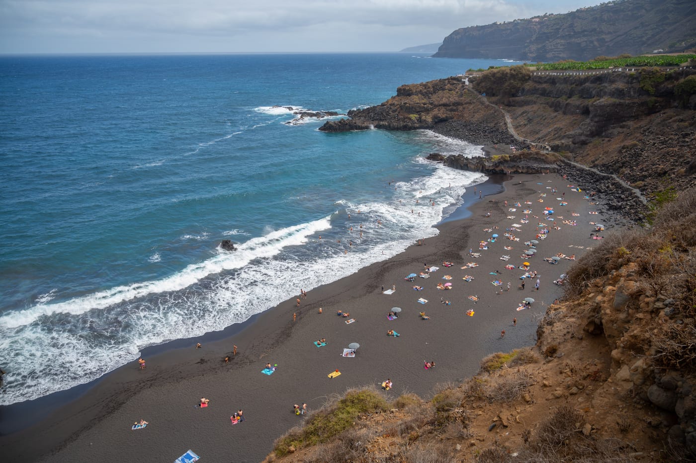 Vista aérea de la Playa del Bollullo, playa virgen de arena negra volcánica al pie de los acantilados de La Orotava, en la costa de Puerto de la Cruz (Tenerife).