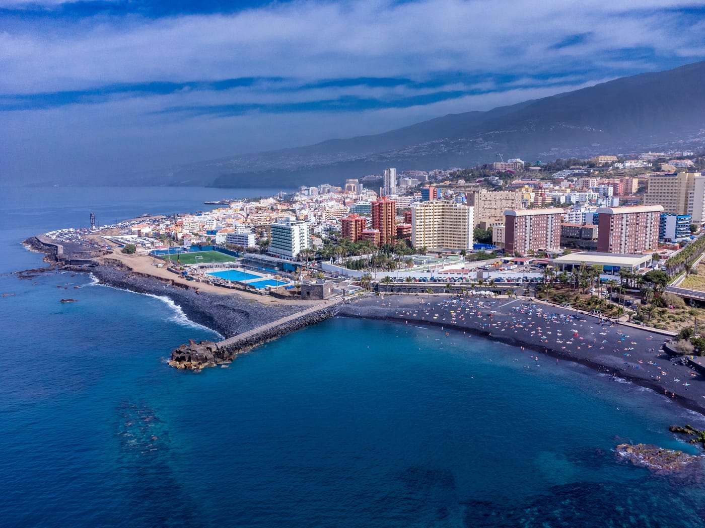 Vista aérea de la Playa Jardín de arena negra, con Puerto de la Cruz al fondo, Tenerife.