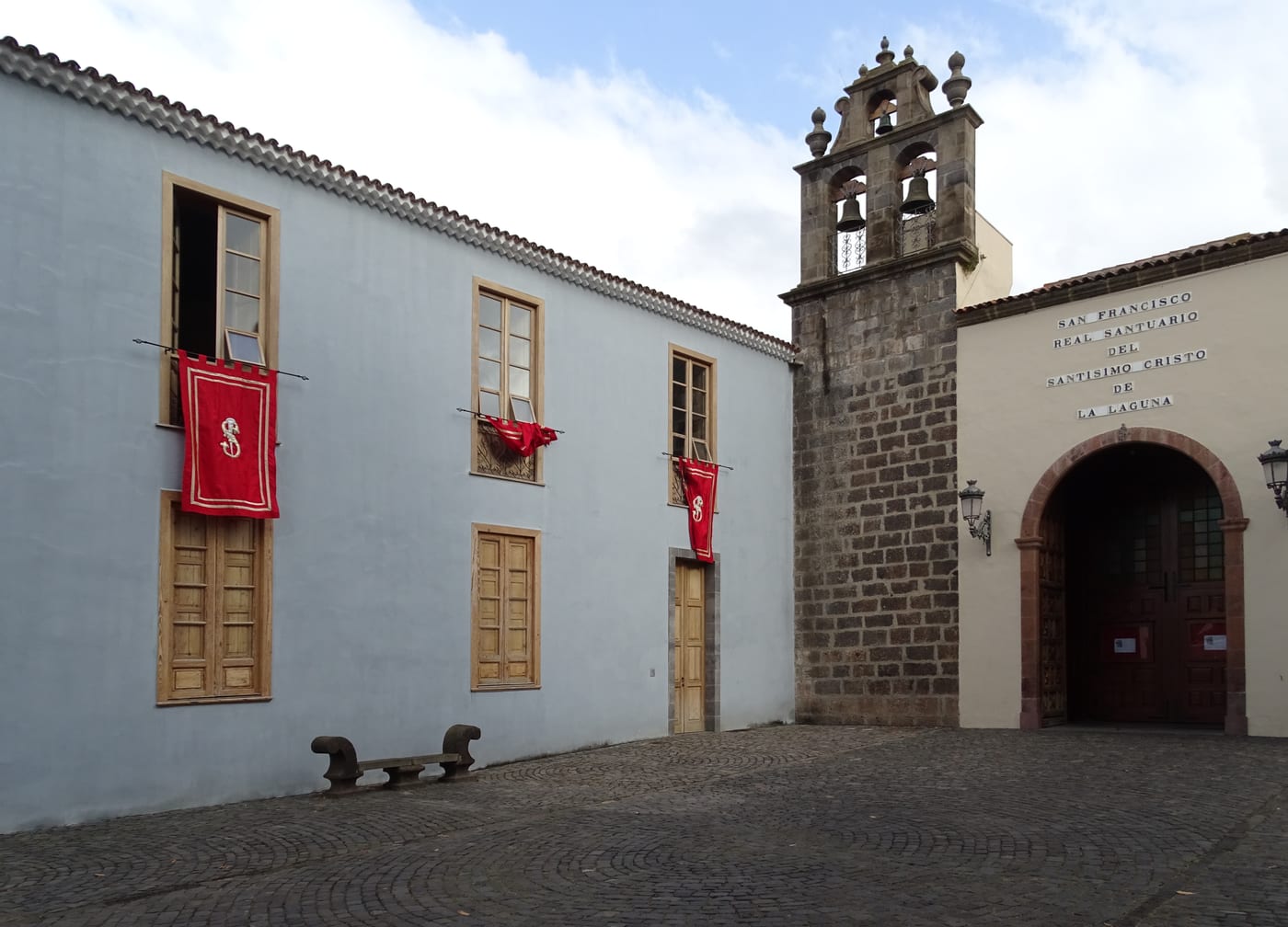 Campanario y portada de piedra del santuario franciscano, con la inscripción del Real Santuario