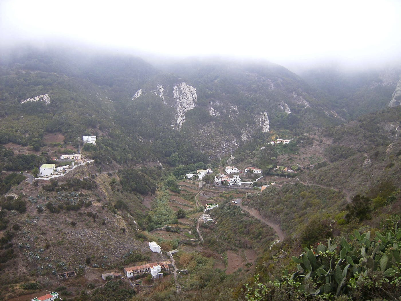 Vista del valle y caserío de Chamorga, con sus casas blancas y los roques del macizo de Anaga al fondo.