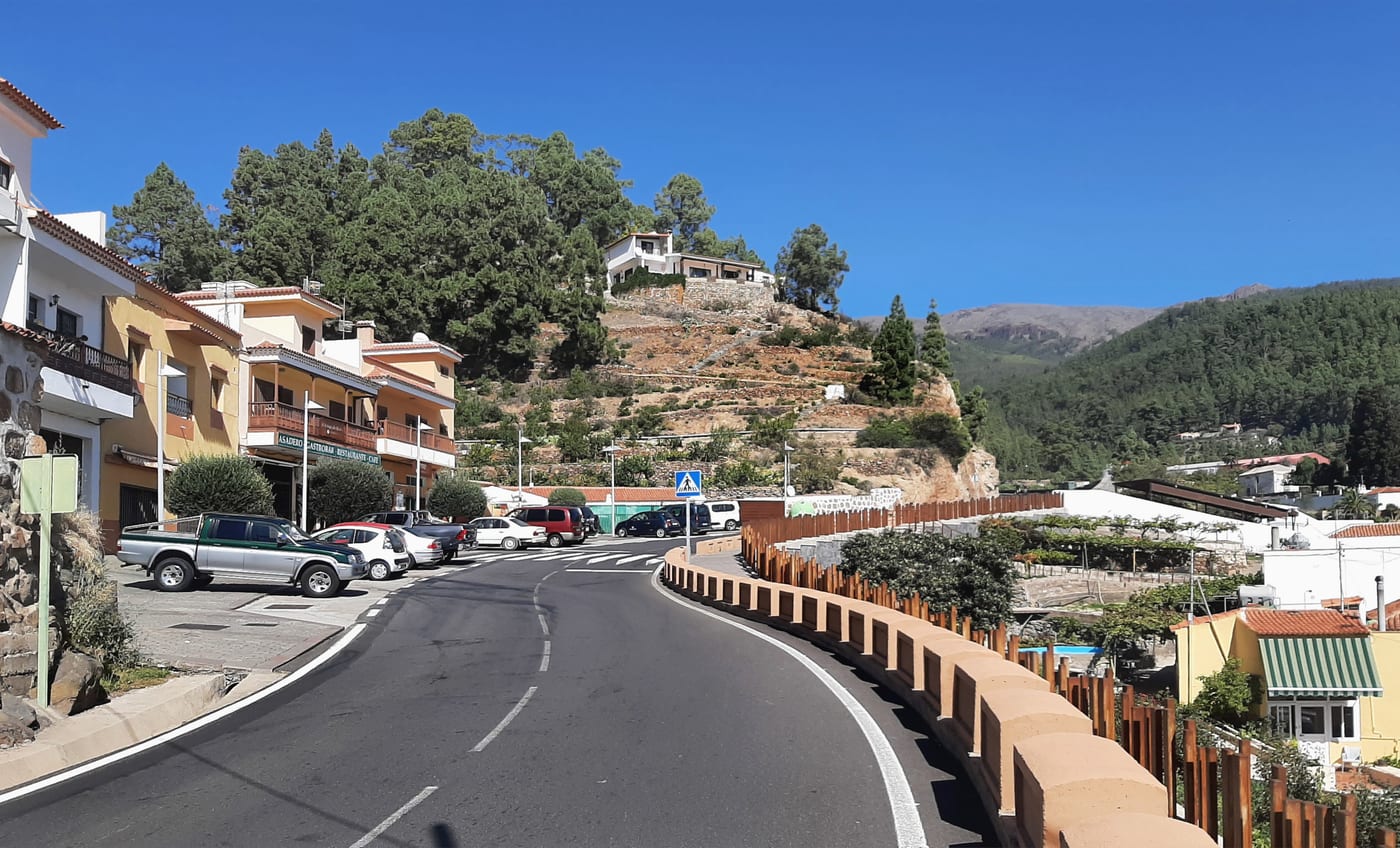 Calle del pueblo de Vilaflor junto a la carretera TF-21, con edificios y comercios locales.